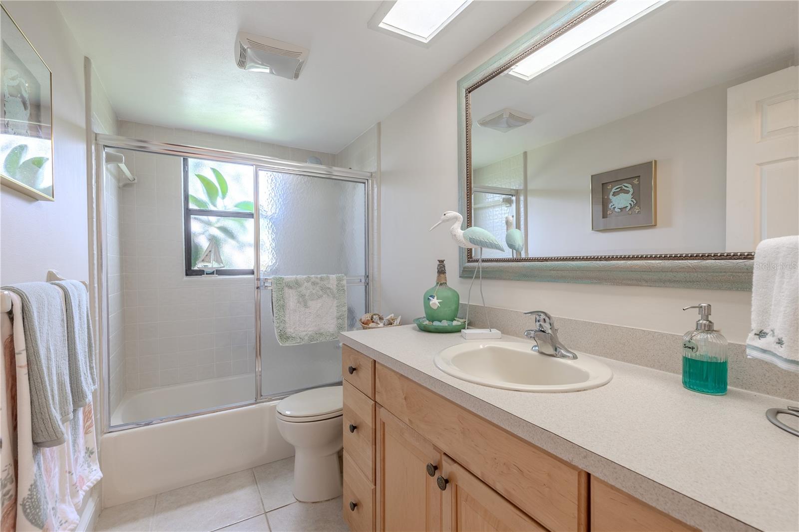 Second full bathroom with large vanity, neutral tones, and updated lighting.