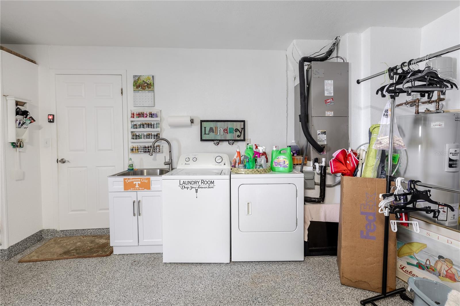 Two-car garage with laundry area, utility sink, and extra storage space.