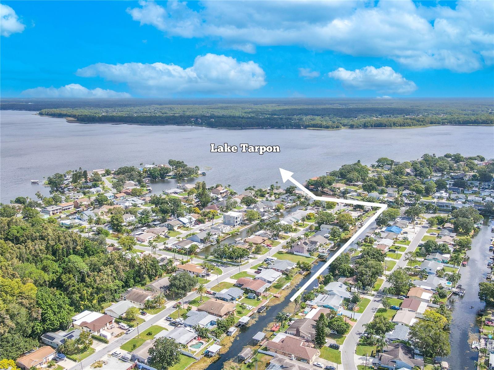 Bird’s-eye perspective of the property and surrounding neighborhood near the water.