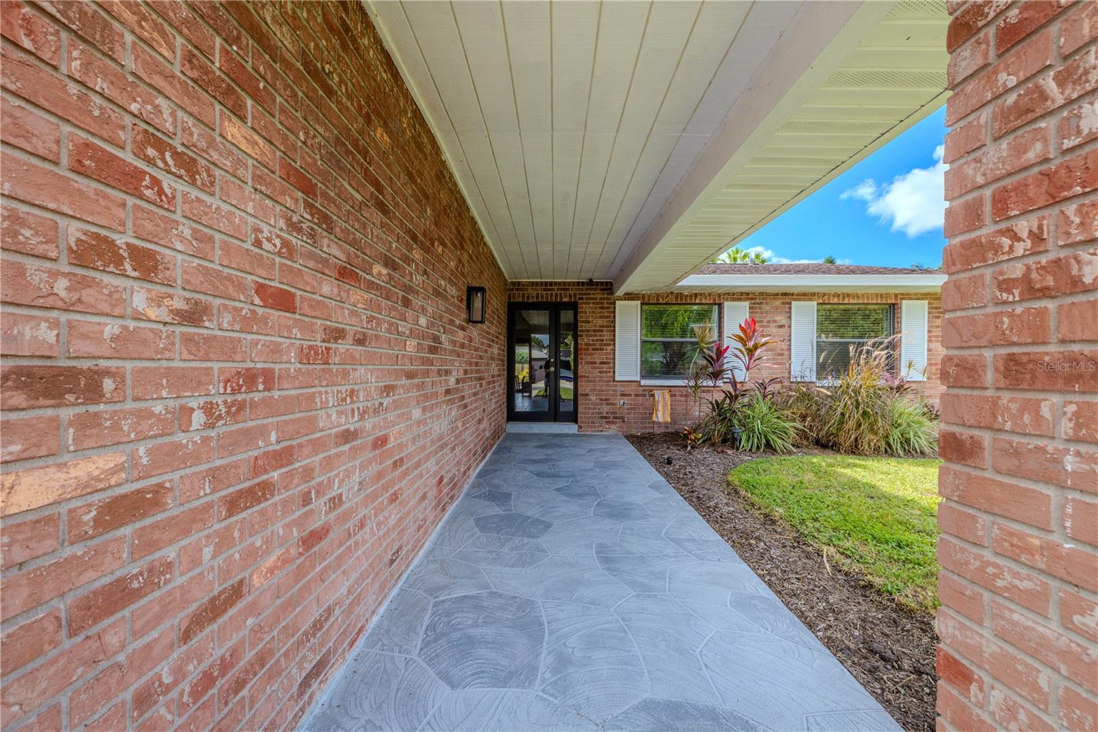 Inviting covered front entry framed by classic brick and clean architectural lines.