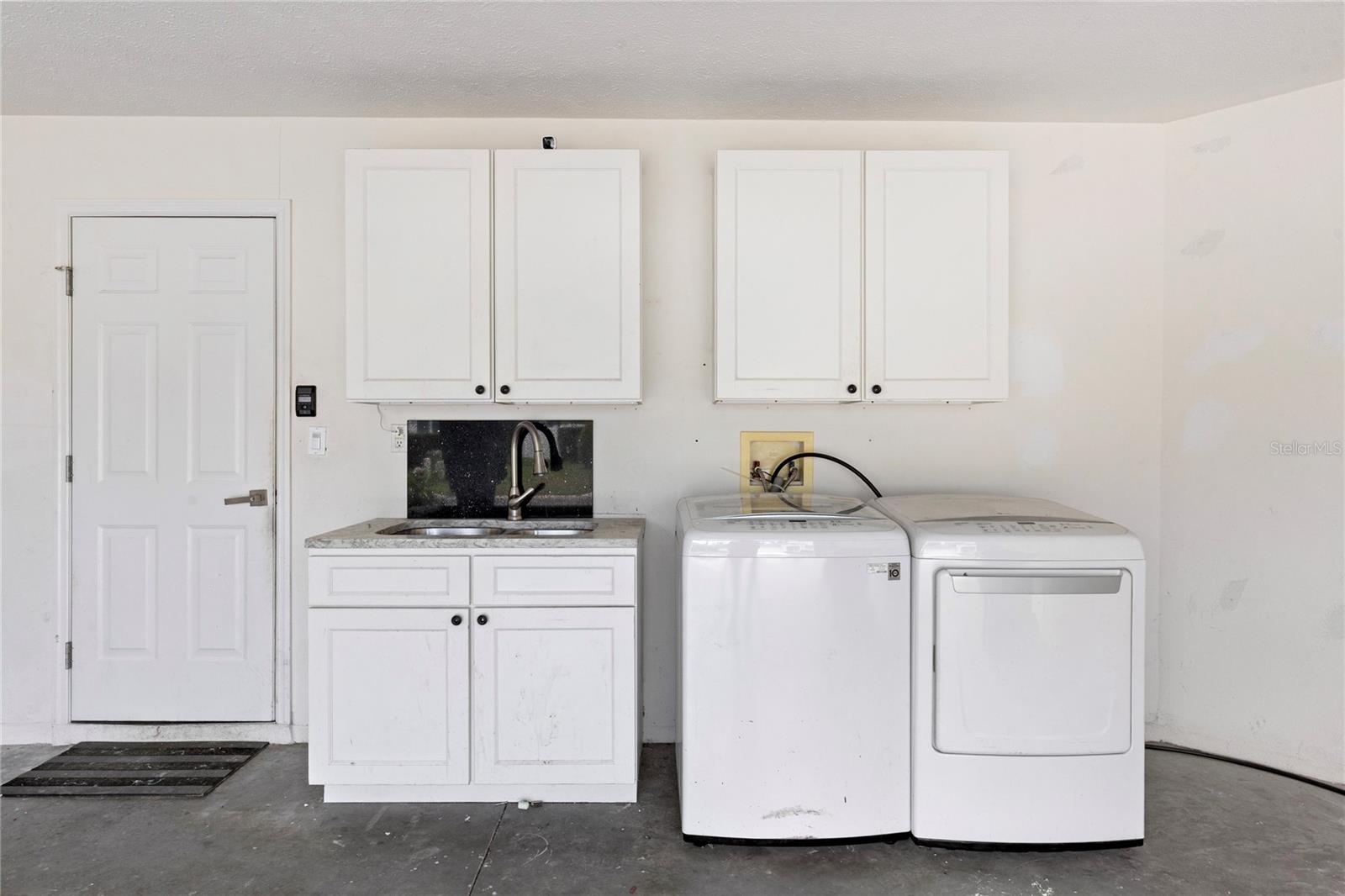 Laundry area in garage with laundry sink