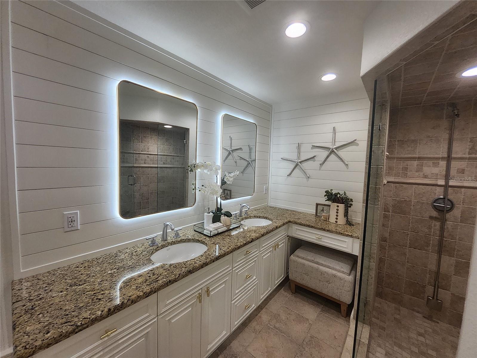Primary bath with double sinks and lighted mirrors