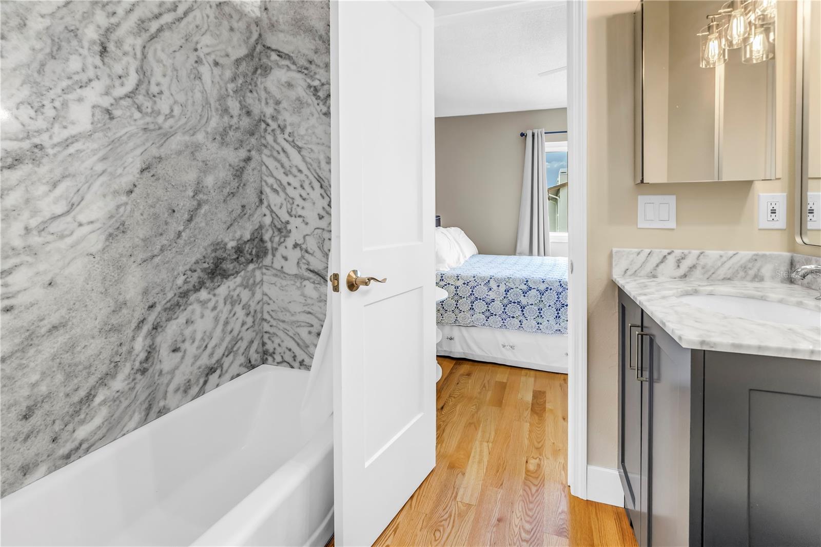 3rd bath with tub and marble tile wall