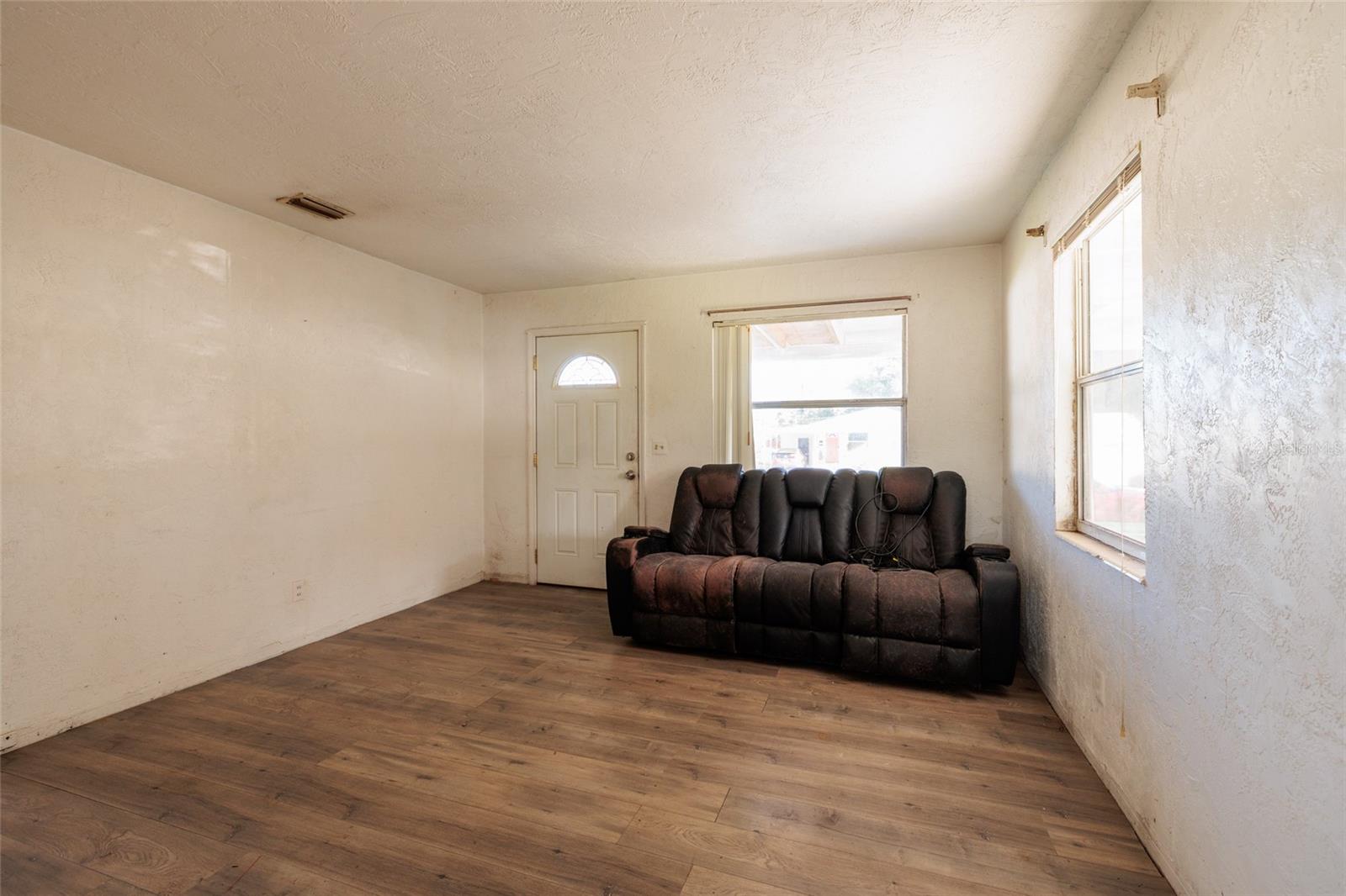 Living room is light filled with 2 big windows