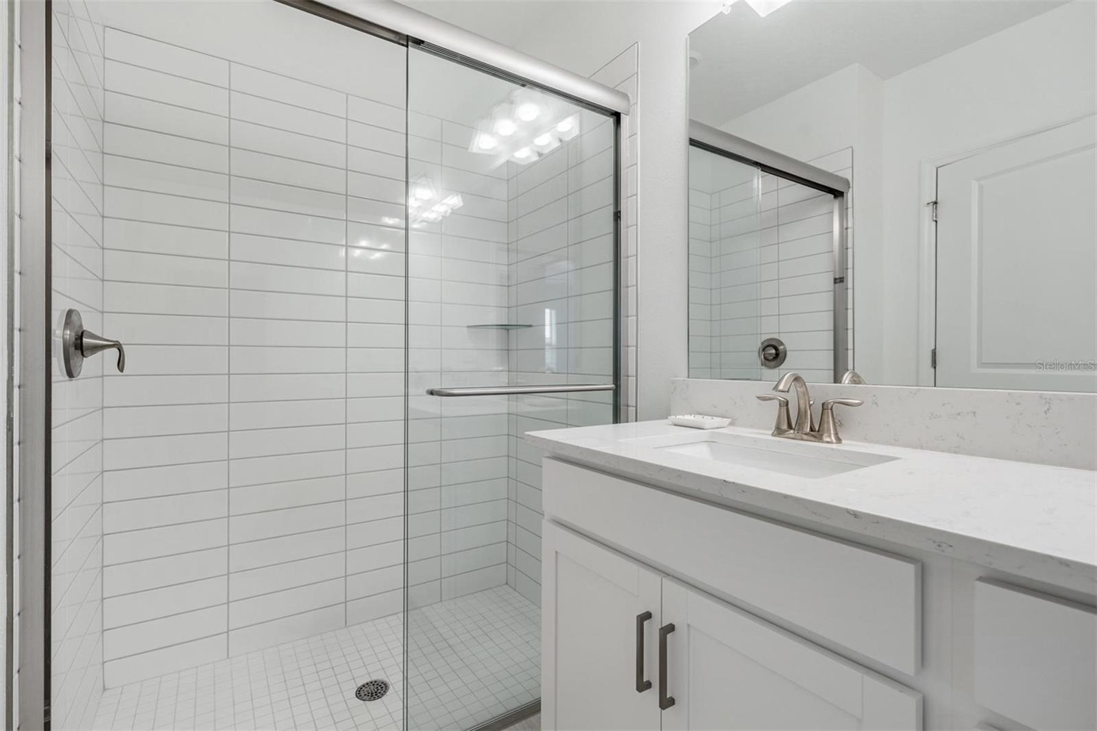 Walk-in shower w/modern white subway tile