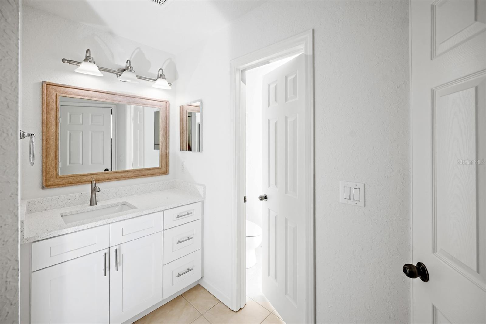 Primary bathroom with Quartz countertops and separate water closet