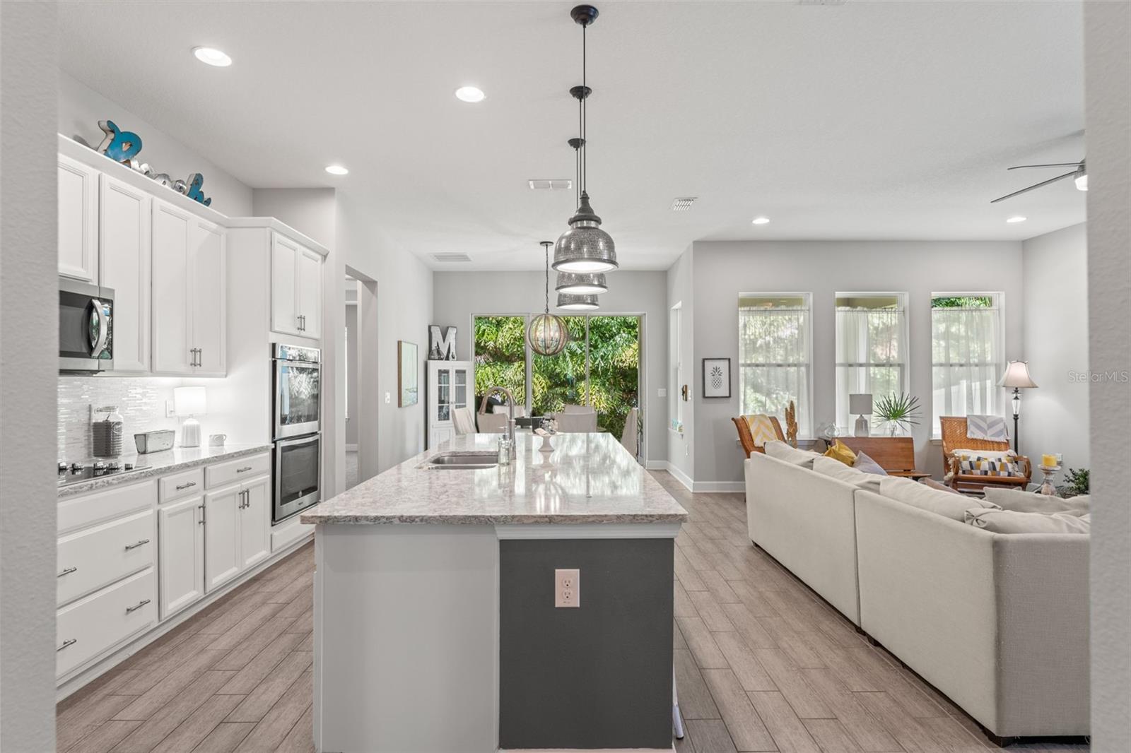 The oversized island offers ample workspace and casual seating, perfect for morning coffee or evening wine with friends.