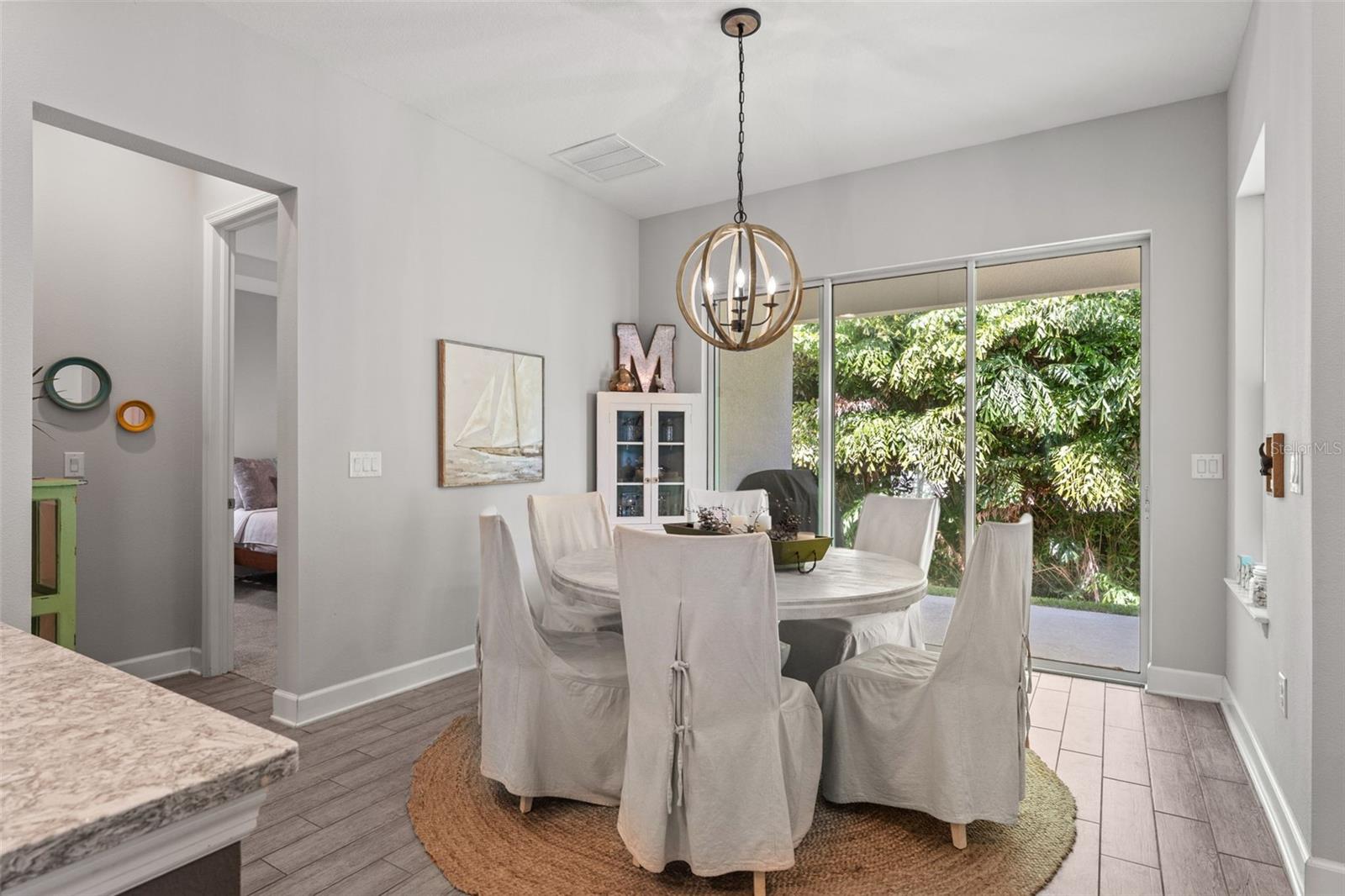 Sunlit dining space framed by large sliding glass doors leading to the covered lanai—perfect for indoor-outdoor Florida living.