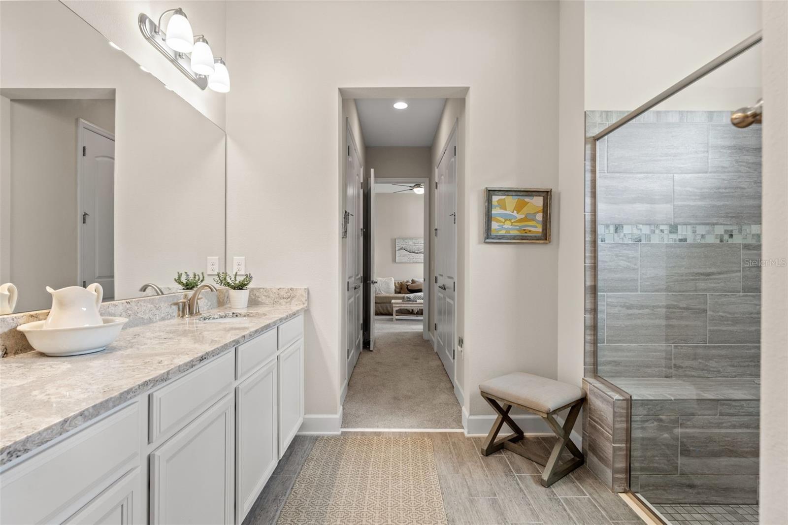Luxurious ensuite bath with dual vanities, granite countertops, and generous storage, blending functionality and elegance.