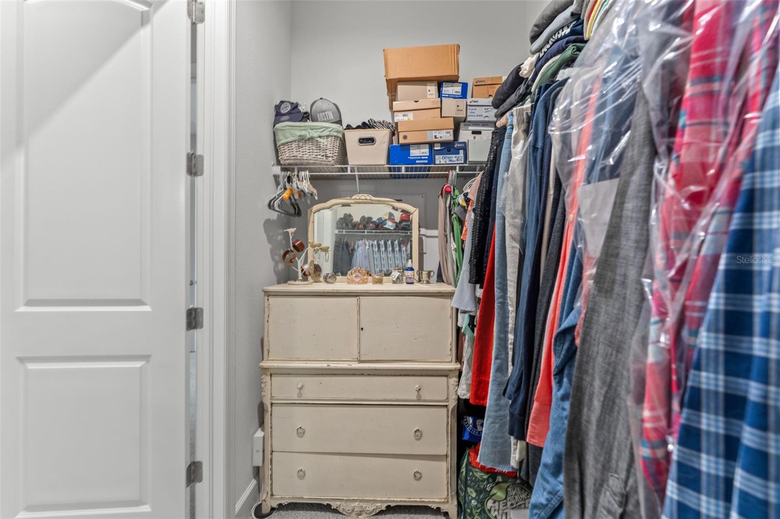 Deep closet layout with built-in shelving and additional space for dressers or personal items.