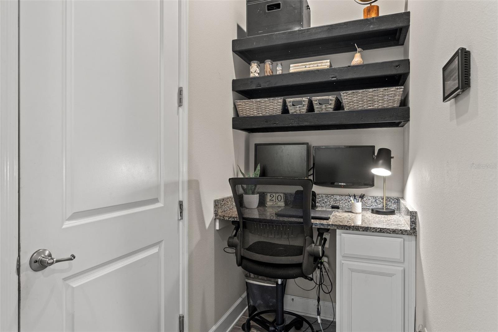 Built-in desk area with granite countertop and custom shelving, perfect for a compact home office, homework station, or craft space.