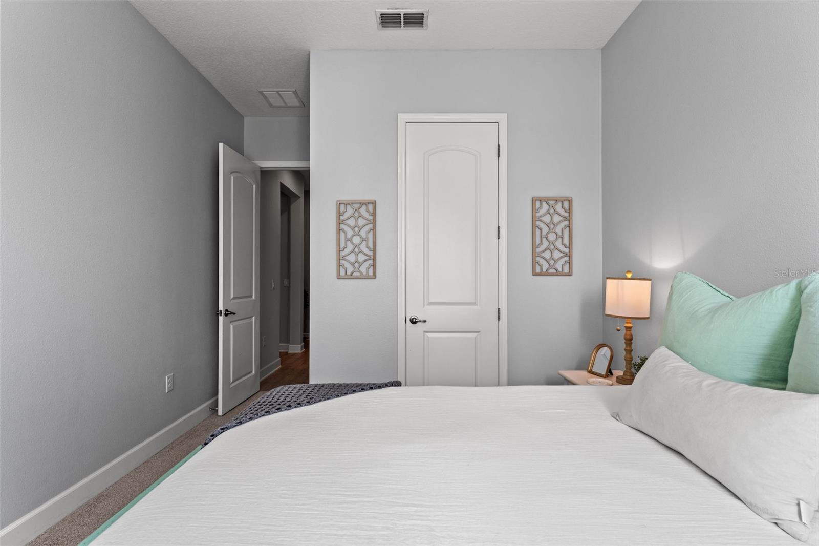 Peaceful retreat showcasing plush carpeting, modern ceiling fan, and stylish accents.