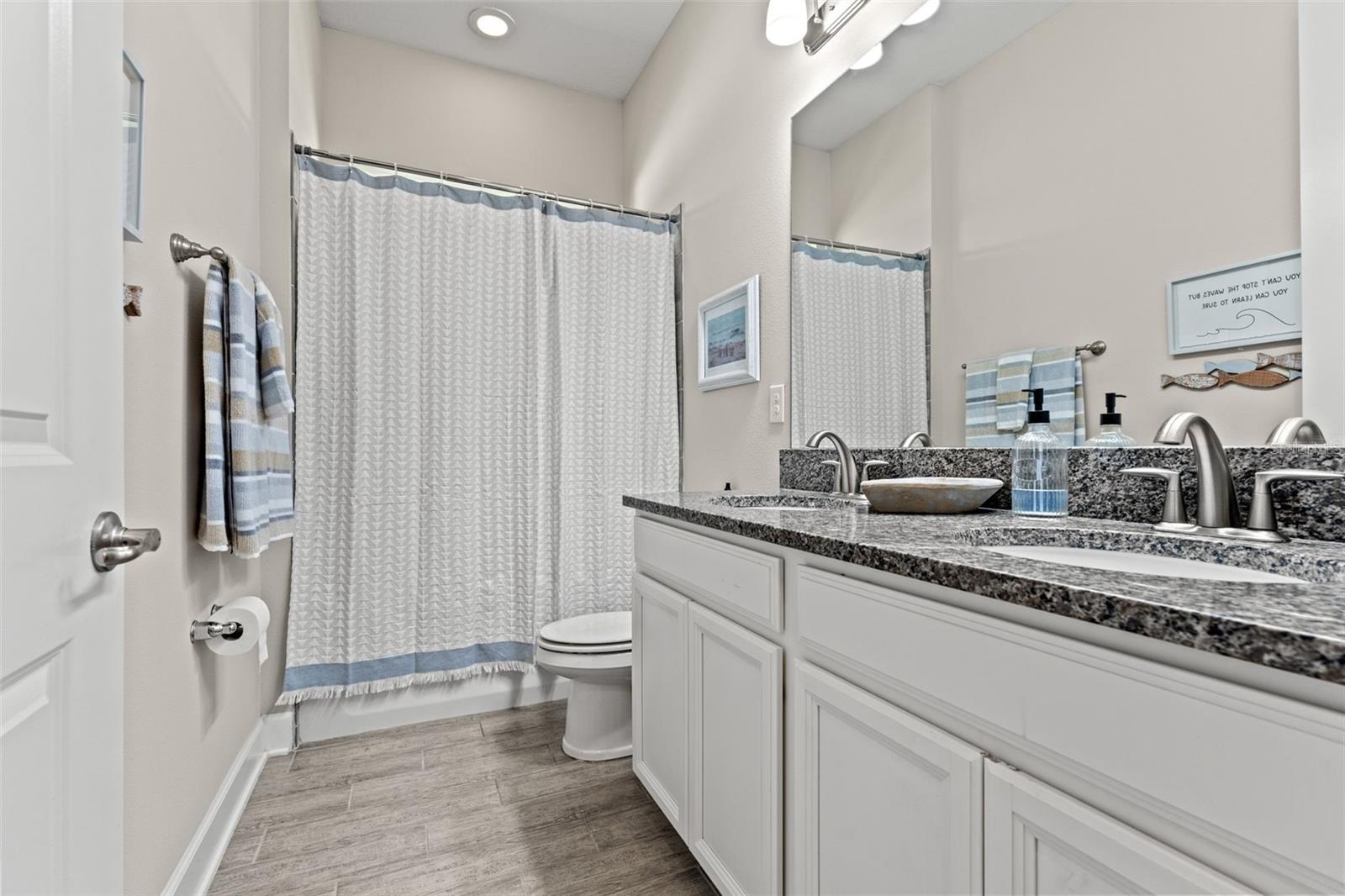 Thoughtfully designed with dual vanities, granite counters, and a shower-tub combo—serving the secondary bedrooms with ease and elegance.