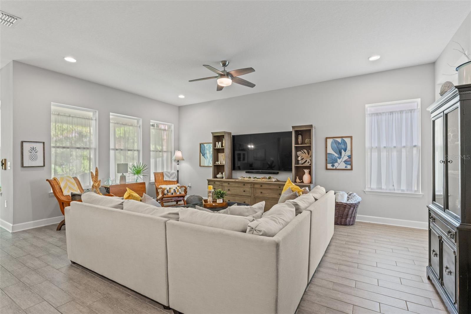 Expansive great room anchored by a large media wall and generous seating area—ideal for movie nights or hosting friends.