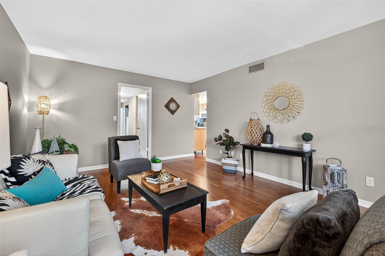 Living room view looking towards primary suite and kitchen doorways