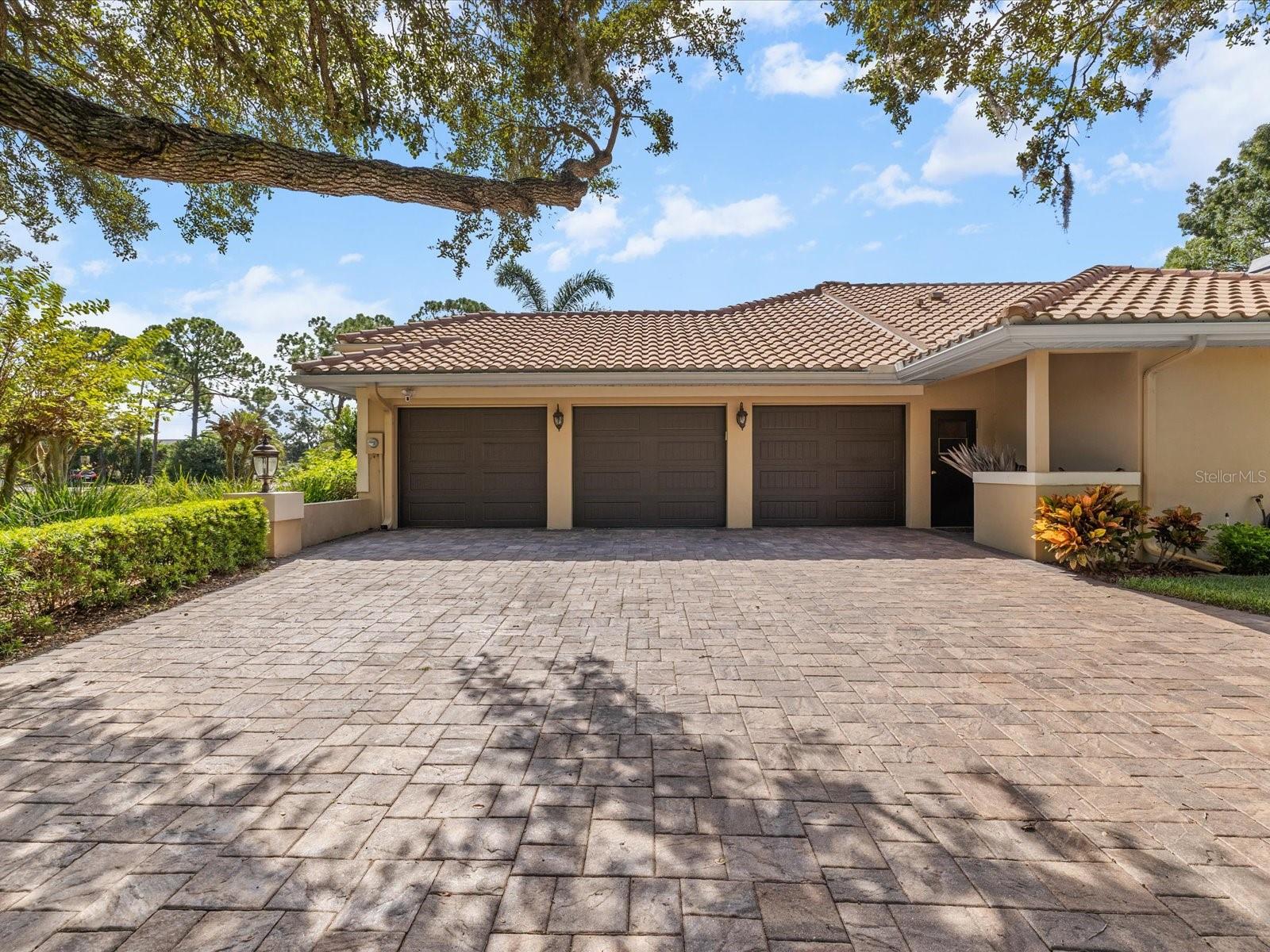 Garage entrance on the right side with pavered driveway