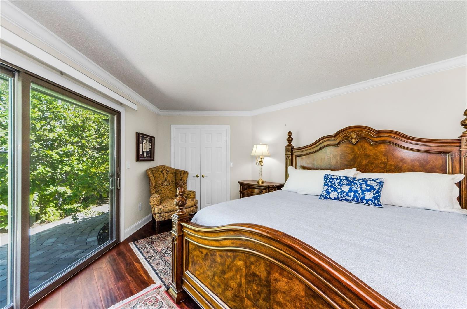 King bed in the master bedroom has a view of the back garden.
