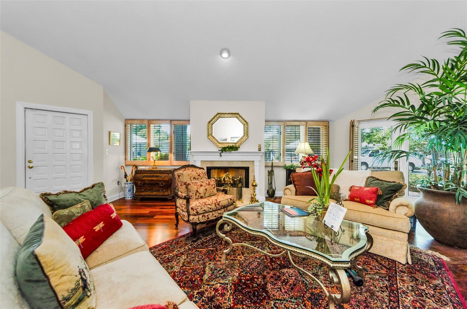 The elegant living room with fireplace and doors out to the brick paved patio on your right.  Note the beautiful tigerwood floors!  Front door on the left.