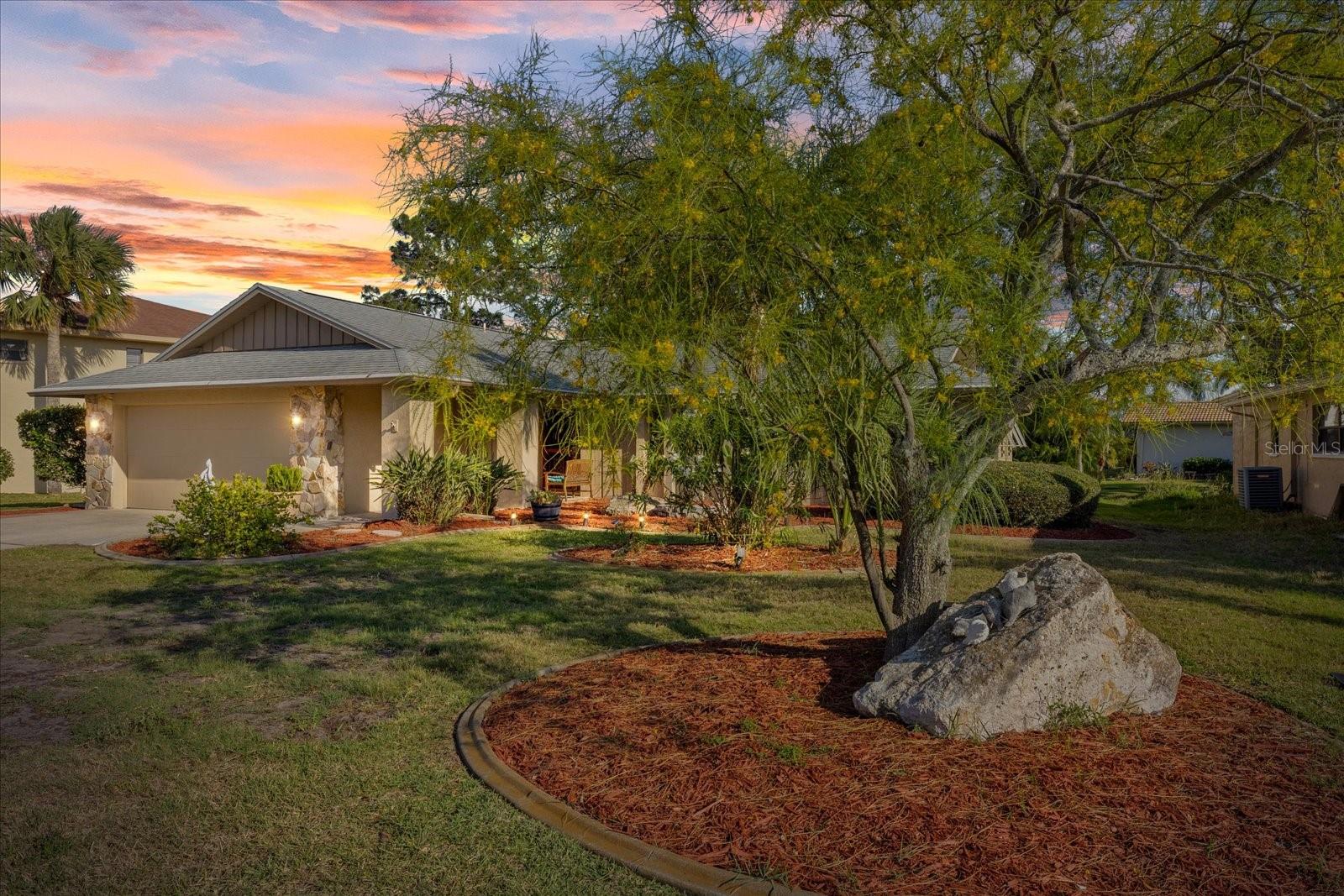Twilight view of landscaped yard