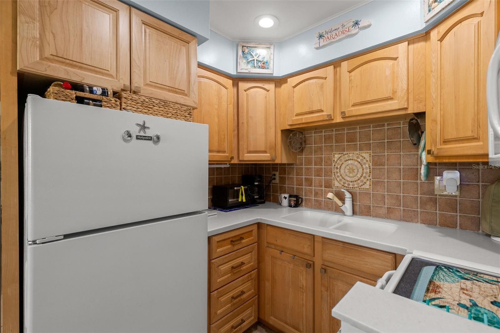 Kitche features light cabinets with plenty of space and Corian countertiops