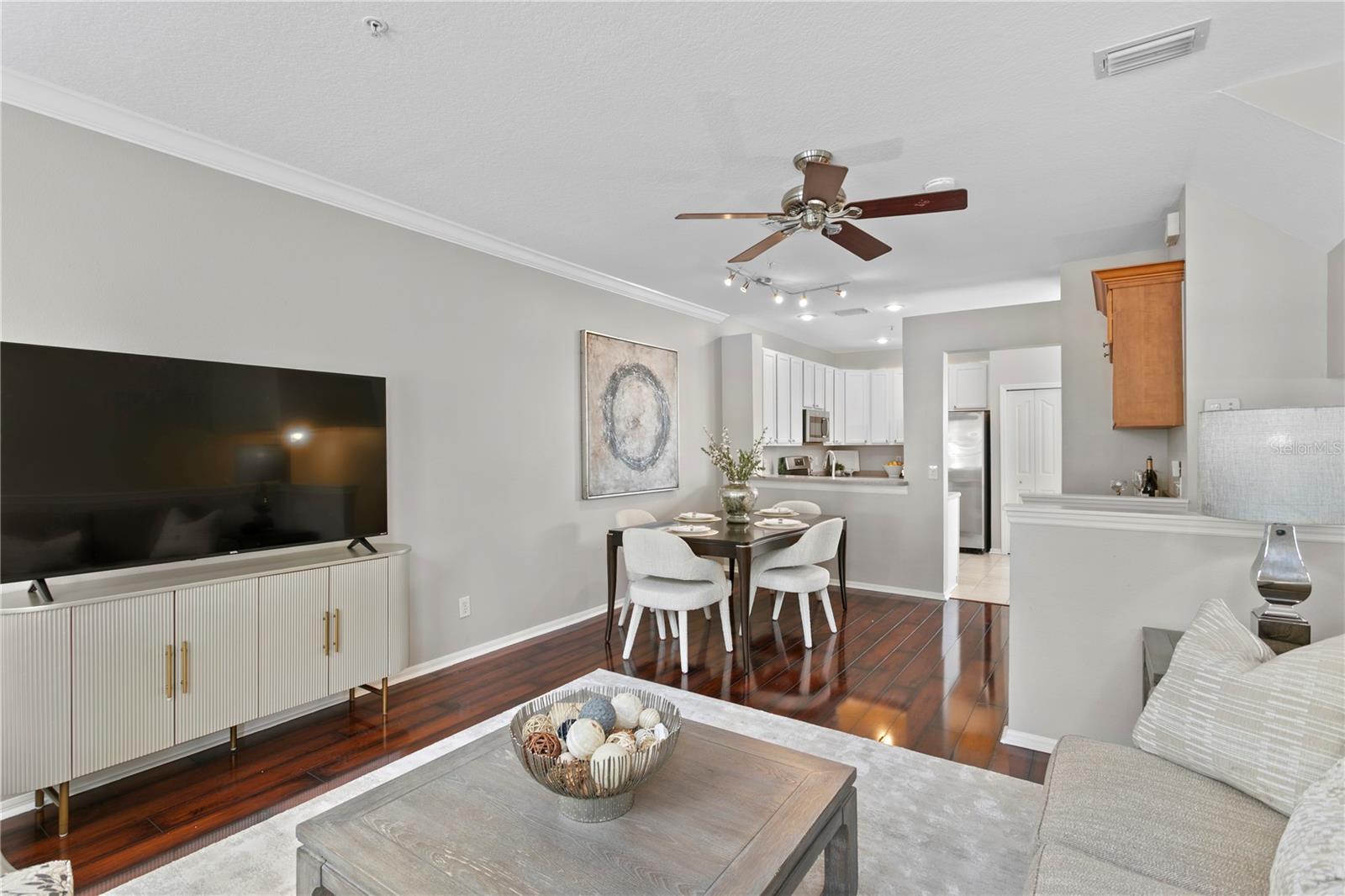 The spacious living room flows seamlessly into the kitchen, which features a convenient dry bar and a space for a dining area—perfect for both everyday living and entertaining.
