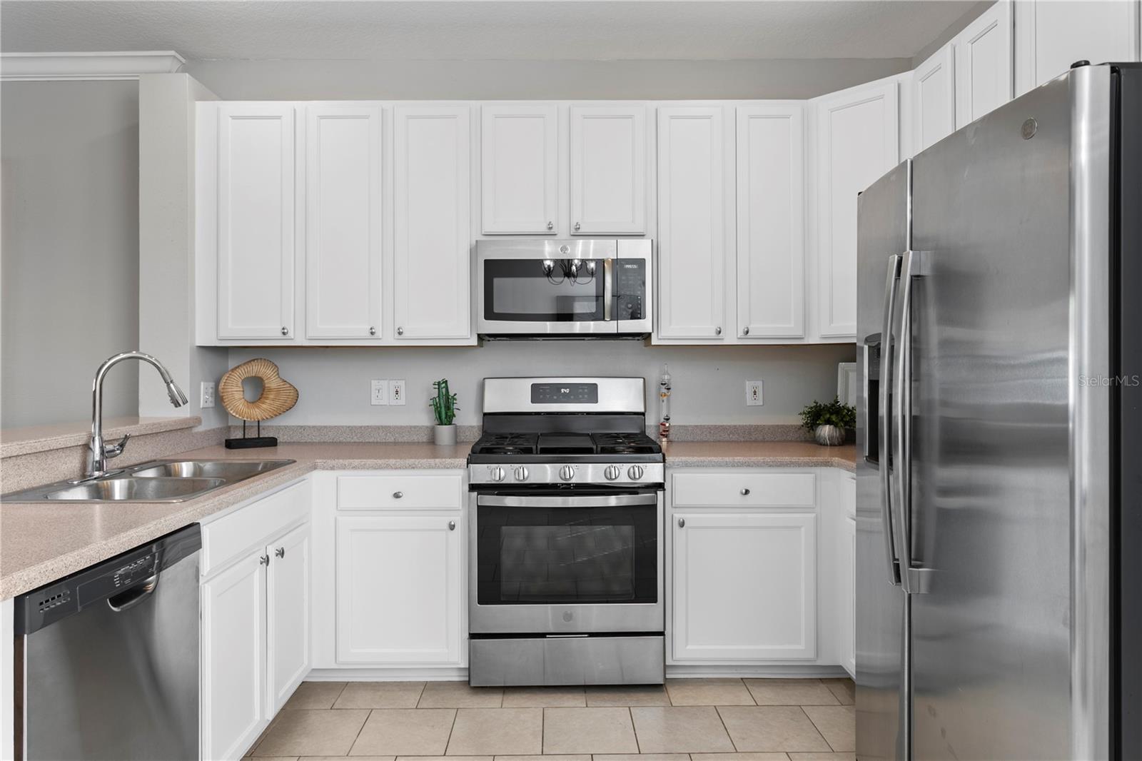 The well-appointed eat-in kitchen featuring abundant cabinetry and prep space and stainless steel appliances