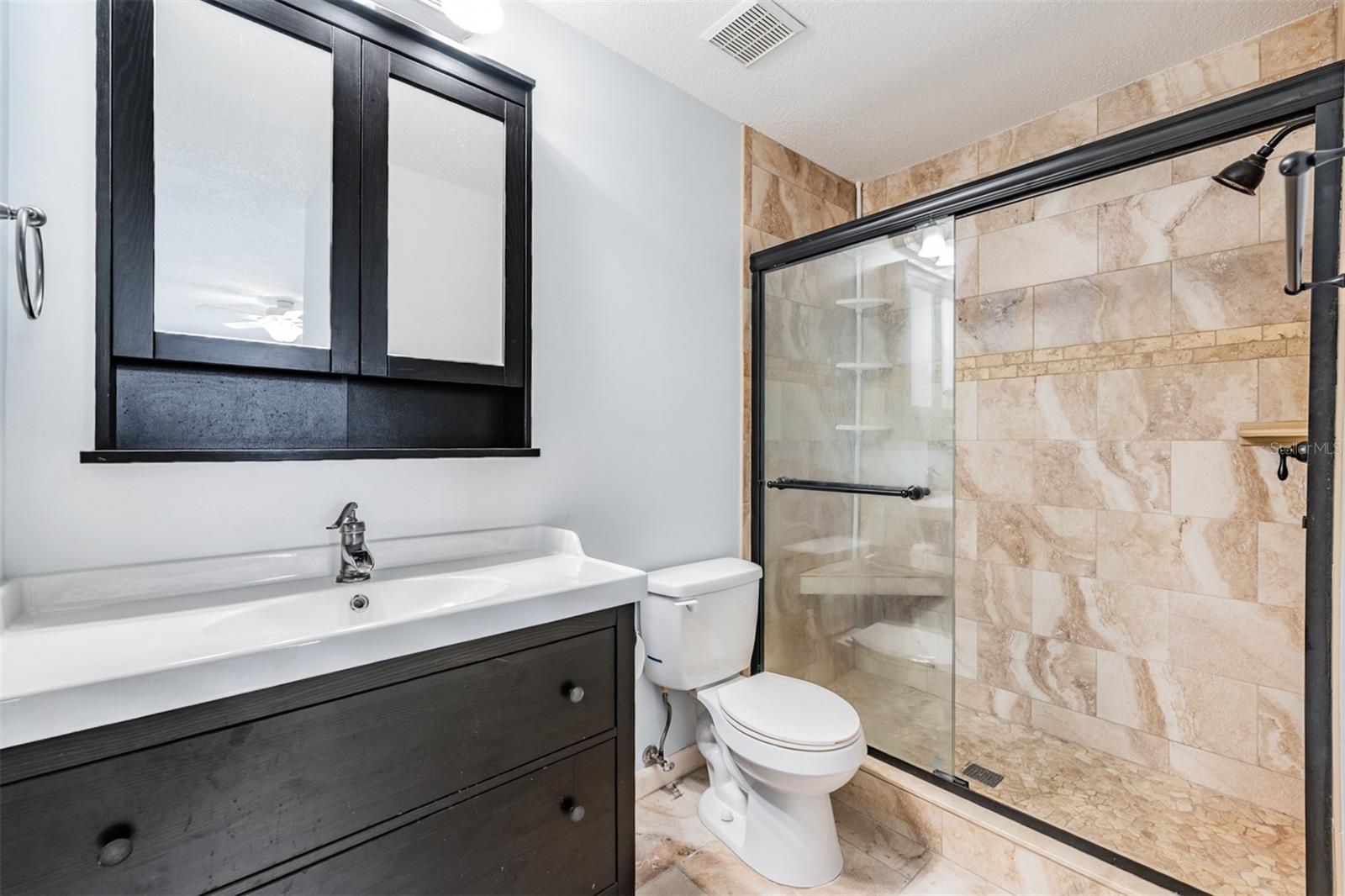 Guest Bathroom, updated vanity/mirror, shower and flooring.