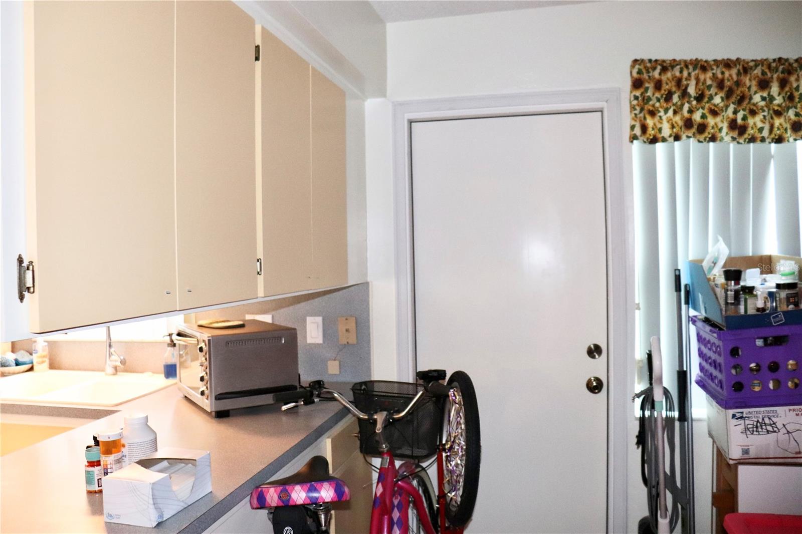 Back door off bonus area and additional kitchen cabinets for storage