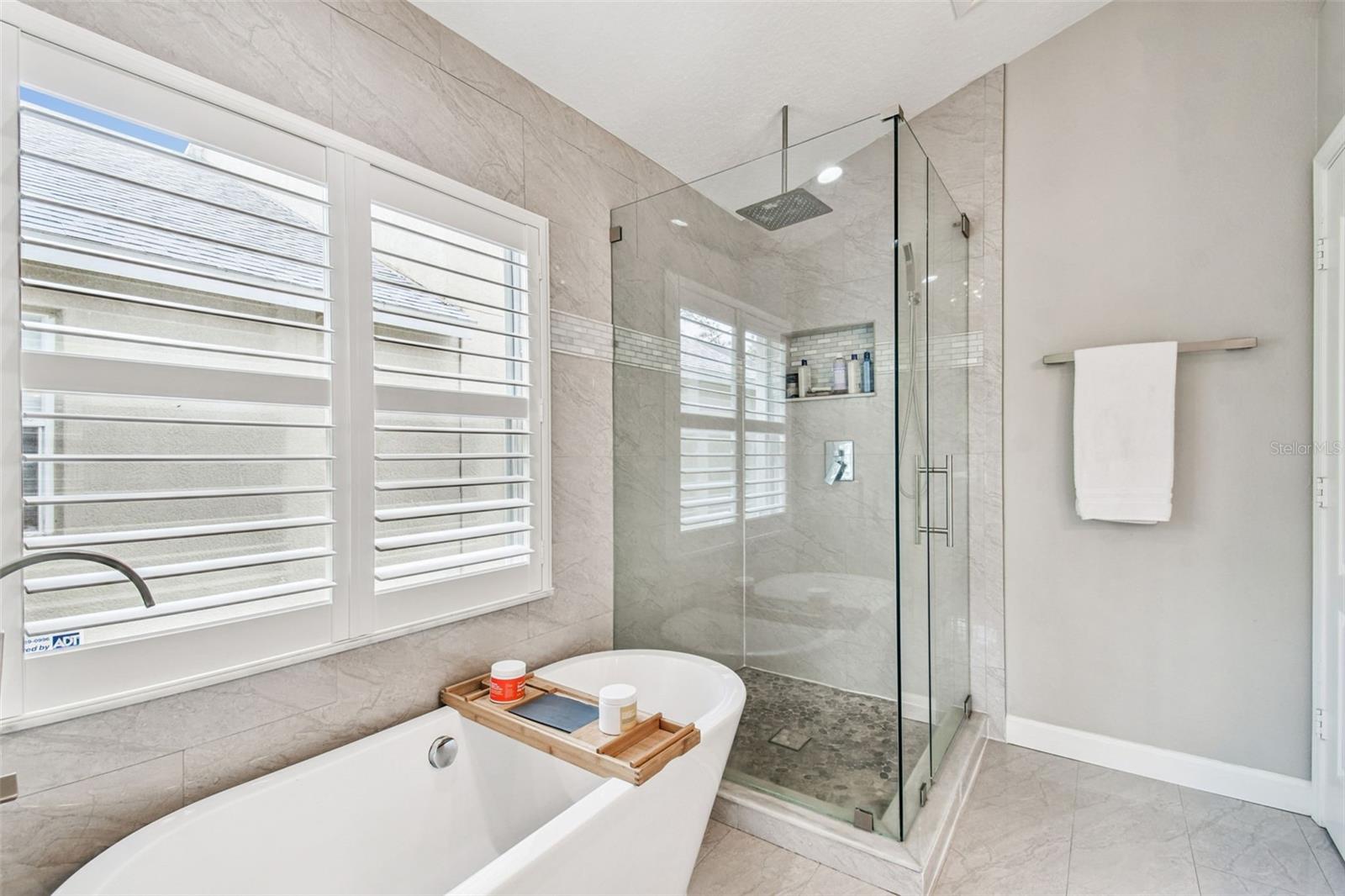 Custom marble mosaic, floor to ceiling tile, frameless glass enclosure