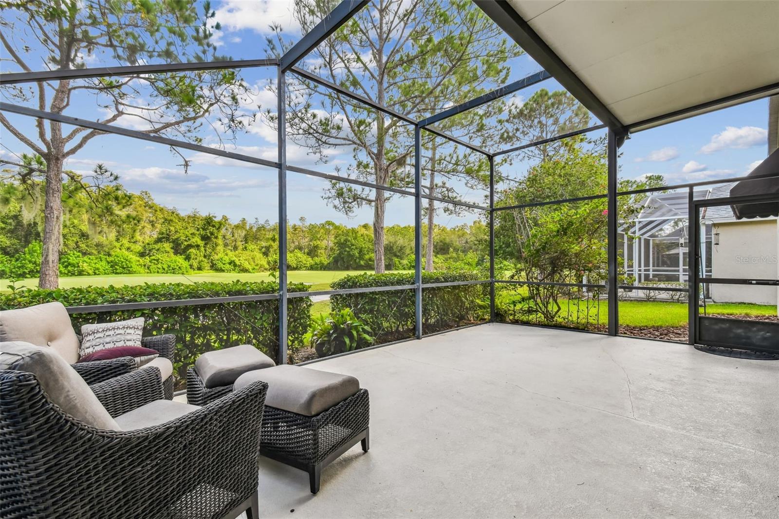 Covered high-frame lanai with serene golf course and forest views