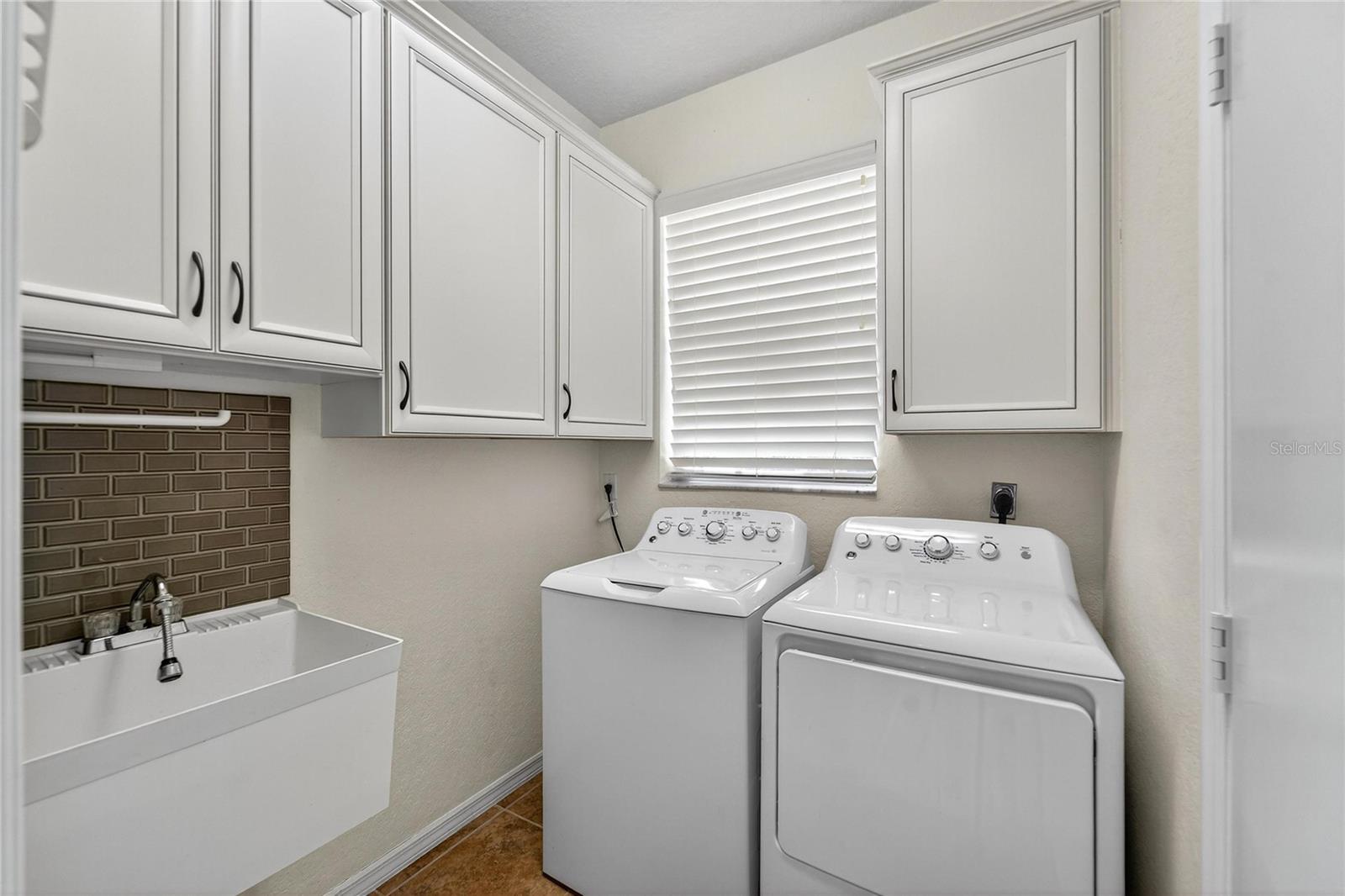 Inside laundry with laundry sink and cabinets