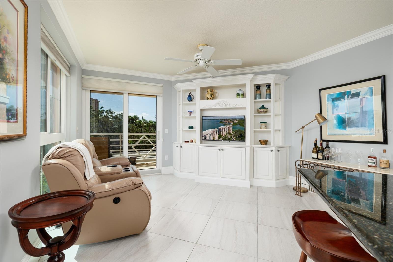 Family Room w/Built in shelves, crown molding & views of the intracoastal waterway. 24x24 Porcelain tile.