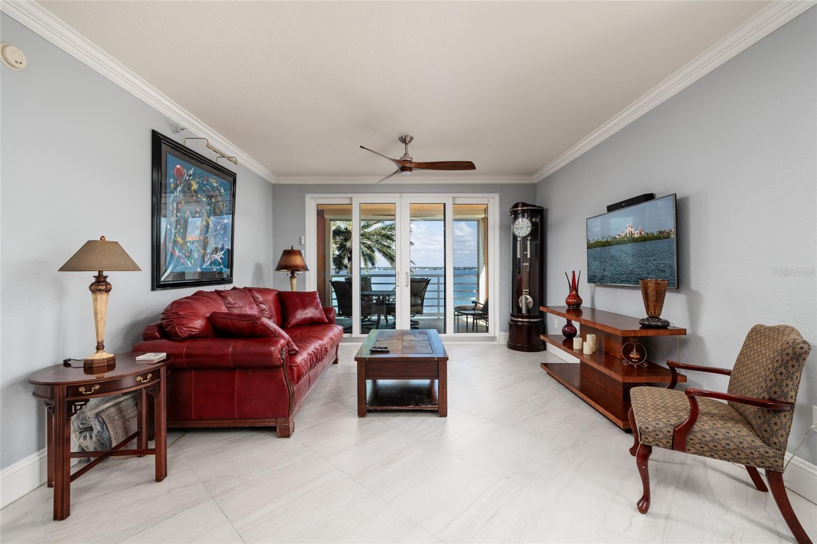 Living room w/2023 High Impact slider to balcony & views of Boca Ciega Bay. Crown molding.