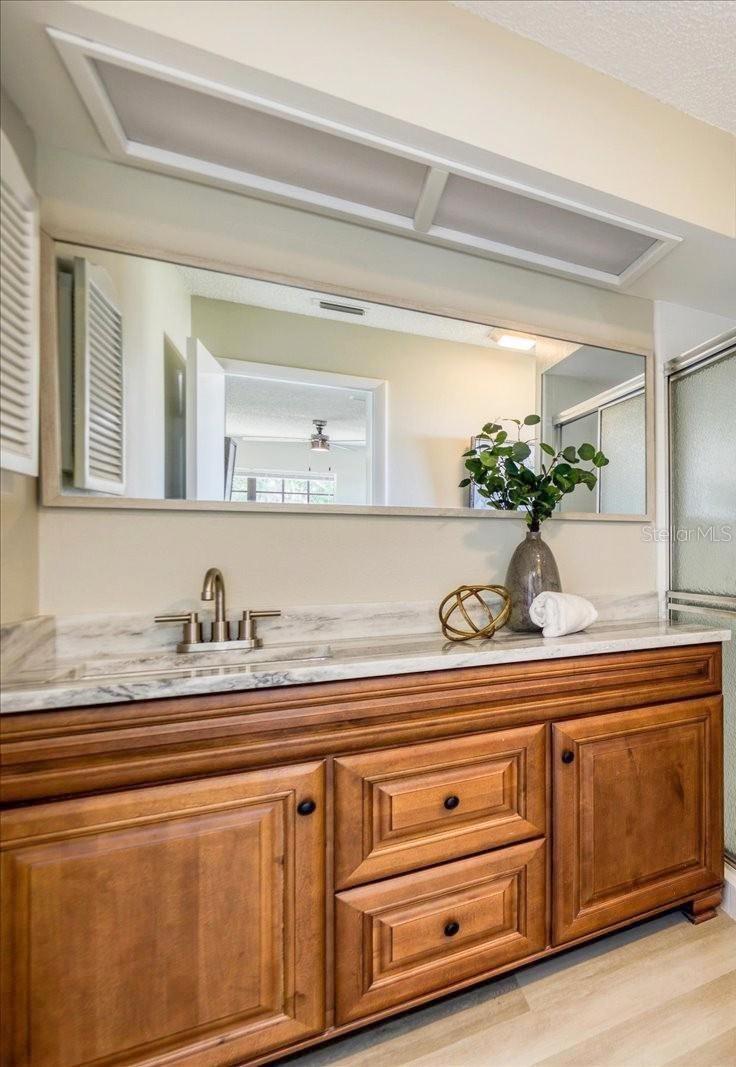 Updated wood vanity, fixtures & mirror with quartizite counter~