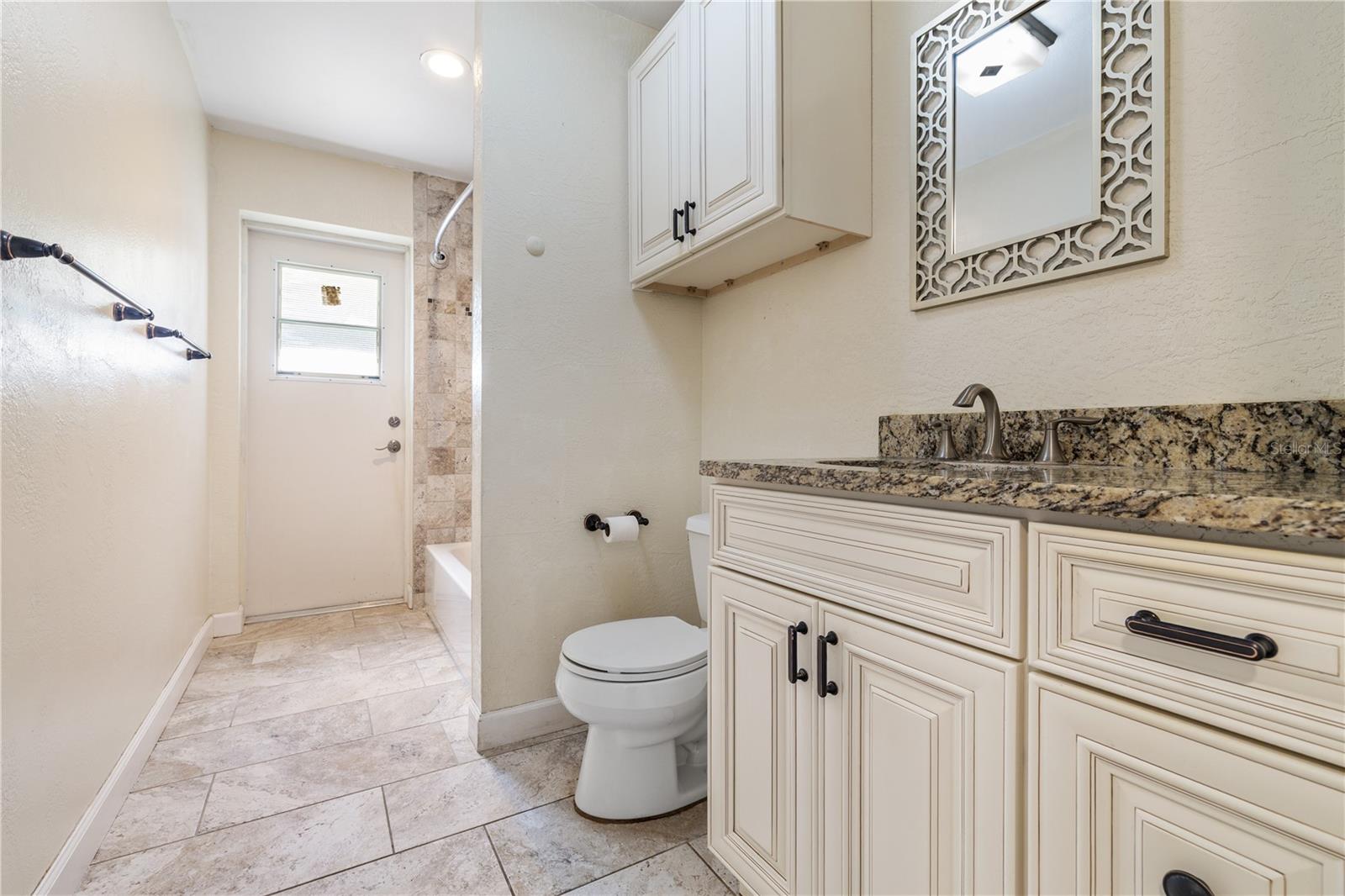 Bath #2 with bathtub & door leading out to rear of home.