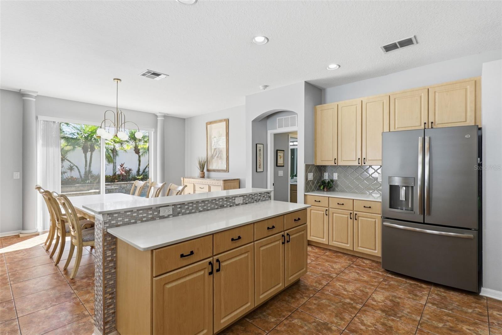 Open-concept kitchen and dining area with gorgeous natural light and backyard pool views—perfect for hosting, dining, and everyday living!