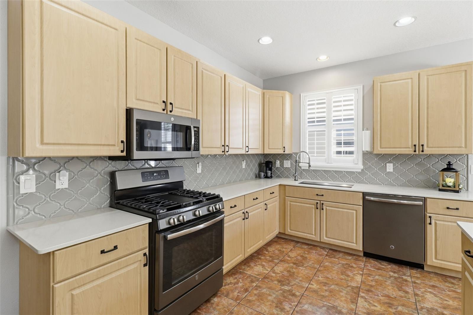 Calling all chefs! This bright kitchen shines with quartz countertops, upgraded appliances, a gas range, and plenty of storage for every gadget.