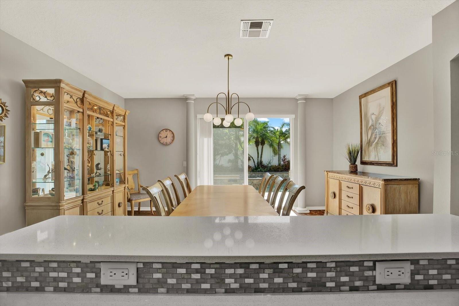 Dinner with a view! Enjoy meals surrounded by natural light and tropical scenery right outside your sliding doors—true Florida living.