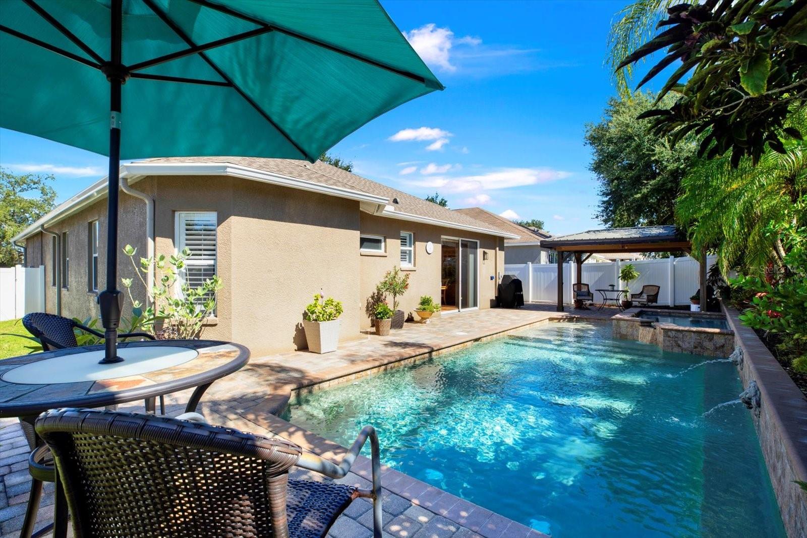 Relax and entertain in your private backyard retreat featuring a heated saltwater pool, spa, and spacious paver patio with gazebo.