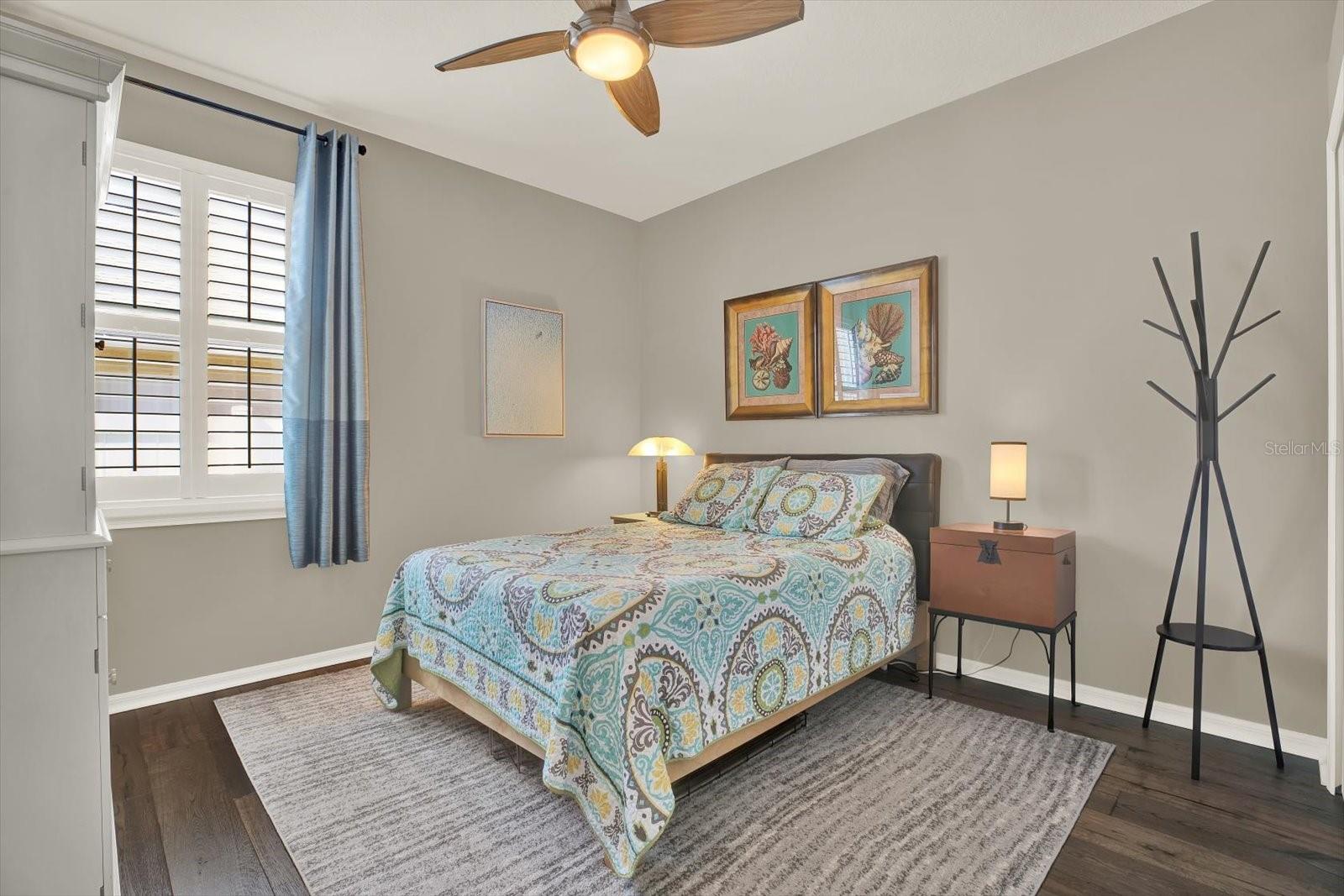 Inviting guest bedroom with beautiful oak hardwood floors, neutral tones, and plenty of natural light—perfect for guests or family.