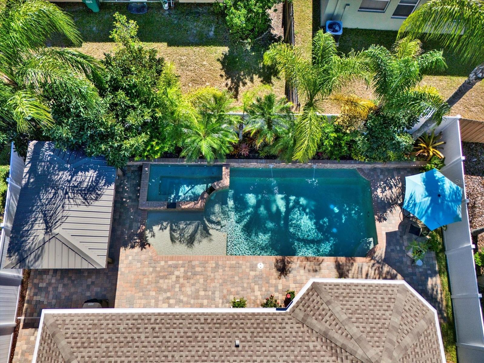 Aerial view of the private, fully fenced backyard surrounded by lush tropical landscaping—your own secluded resort-style oasis.