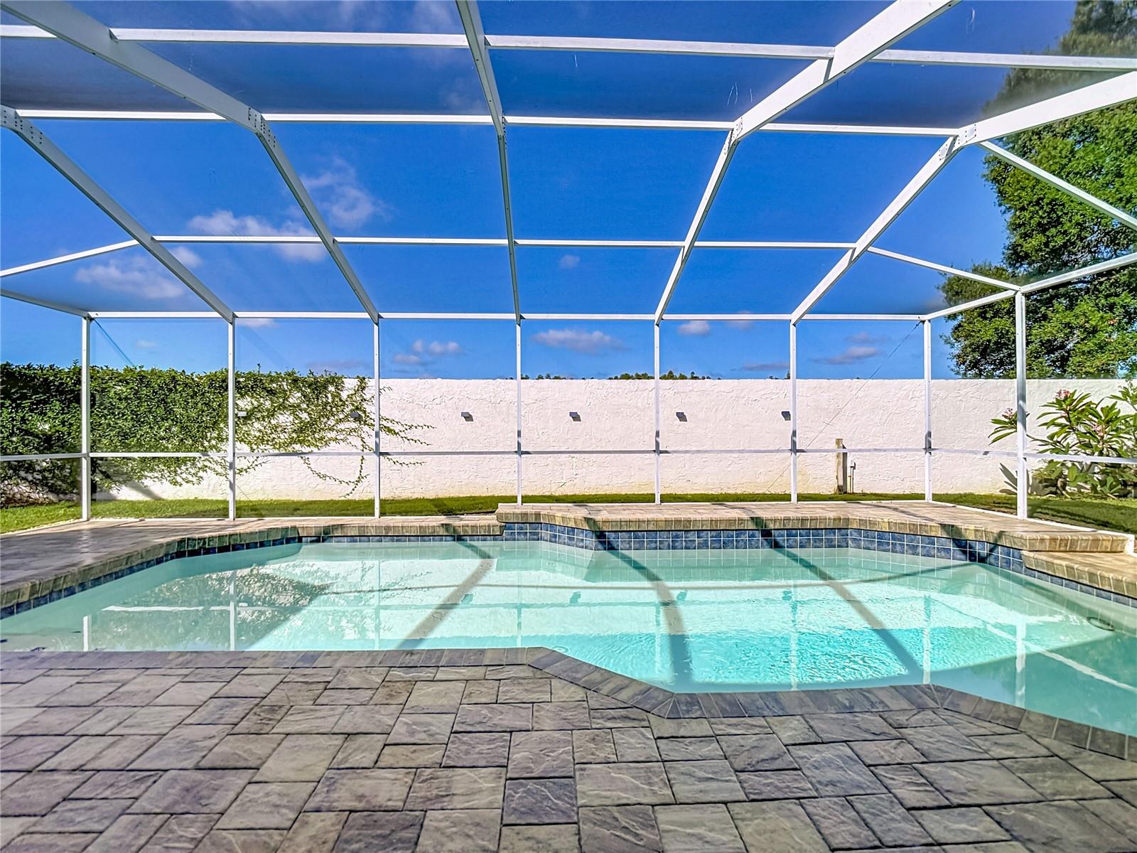 Pavered pool area with privacy wall