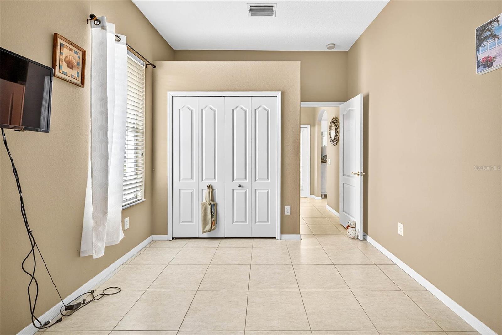 4th Bedroom with view of Pool Door in distance and Kitchen/Family Room Arched Doorway on the right