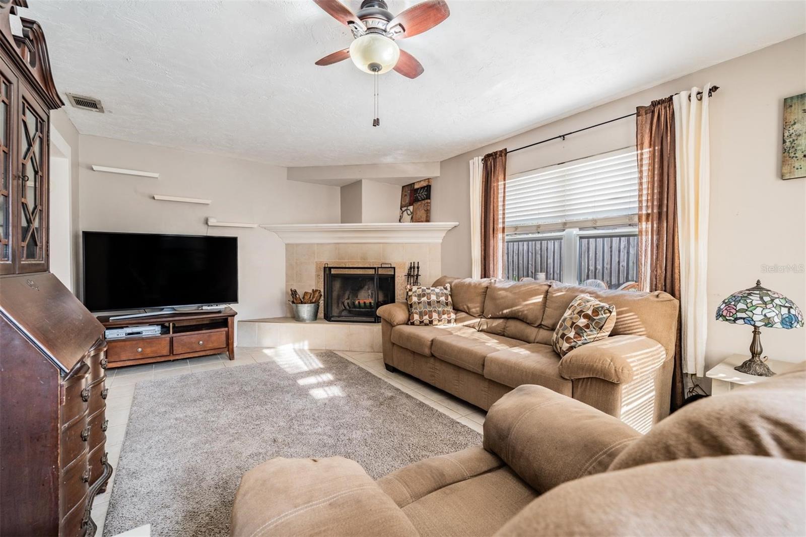 The large den, with its inviting wood-burning fireplace creates a warm and welcoming space for intimate gatherings.