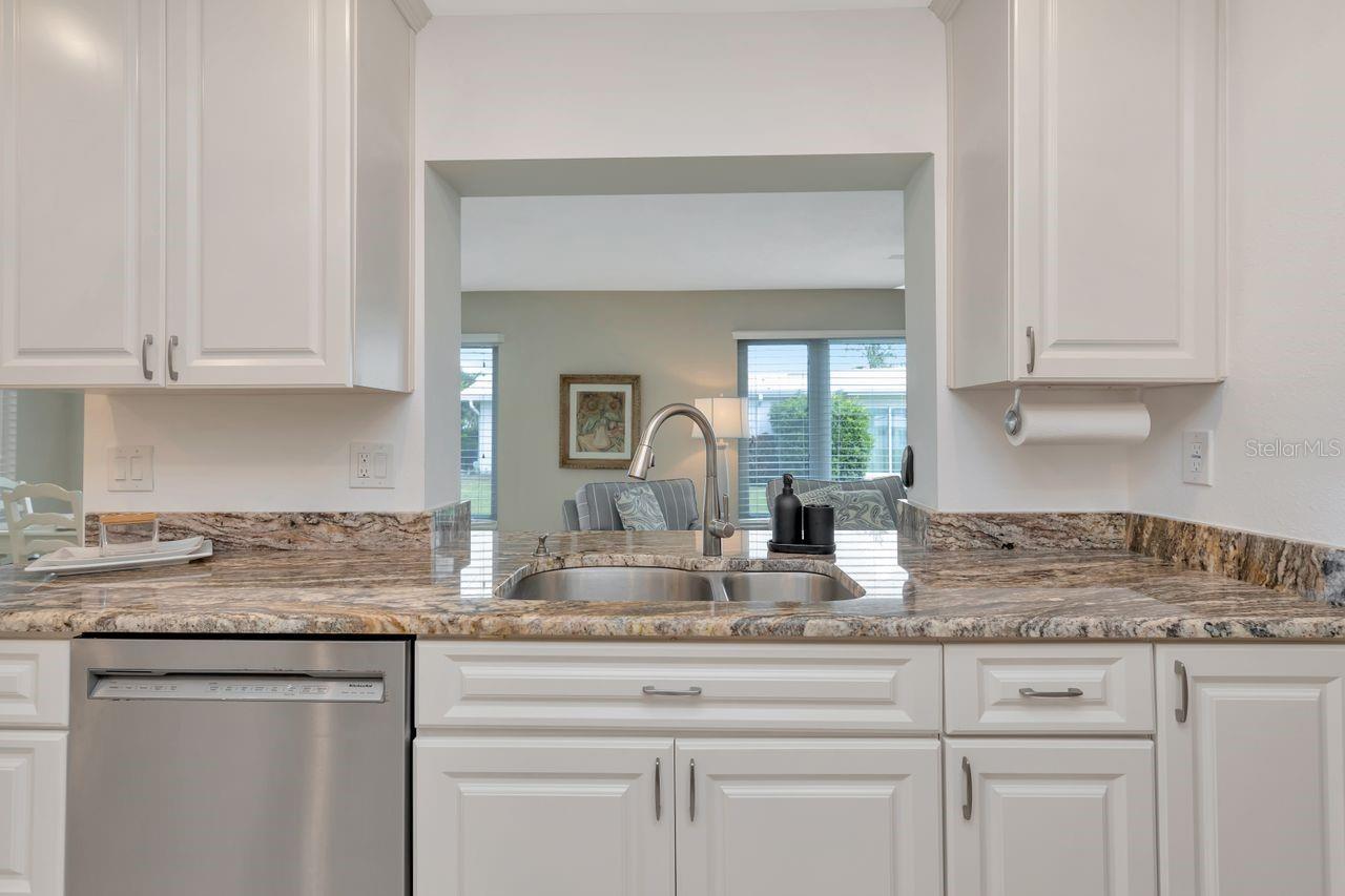 Open area to Sunroom —- Kitchen has many cabinets-doors/drawers