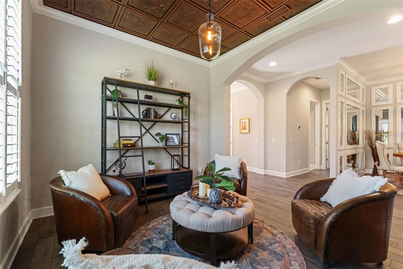 Alternate library view showing plantation shutters, designer lighting, and detailed millwork.