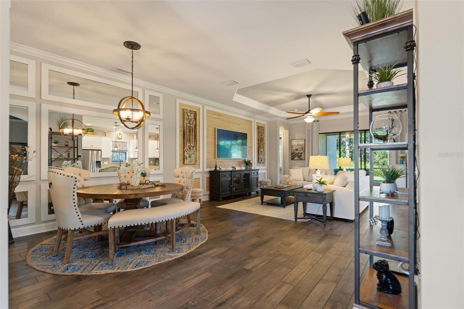 Living and dining space featuring porcelain tile, crown molding, and elegant transitions between rooms.
