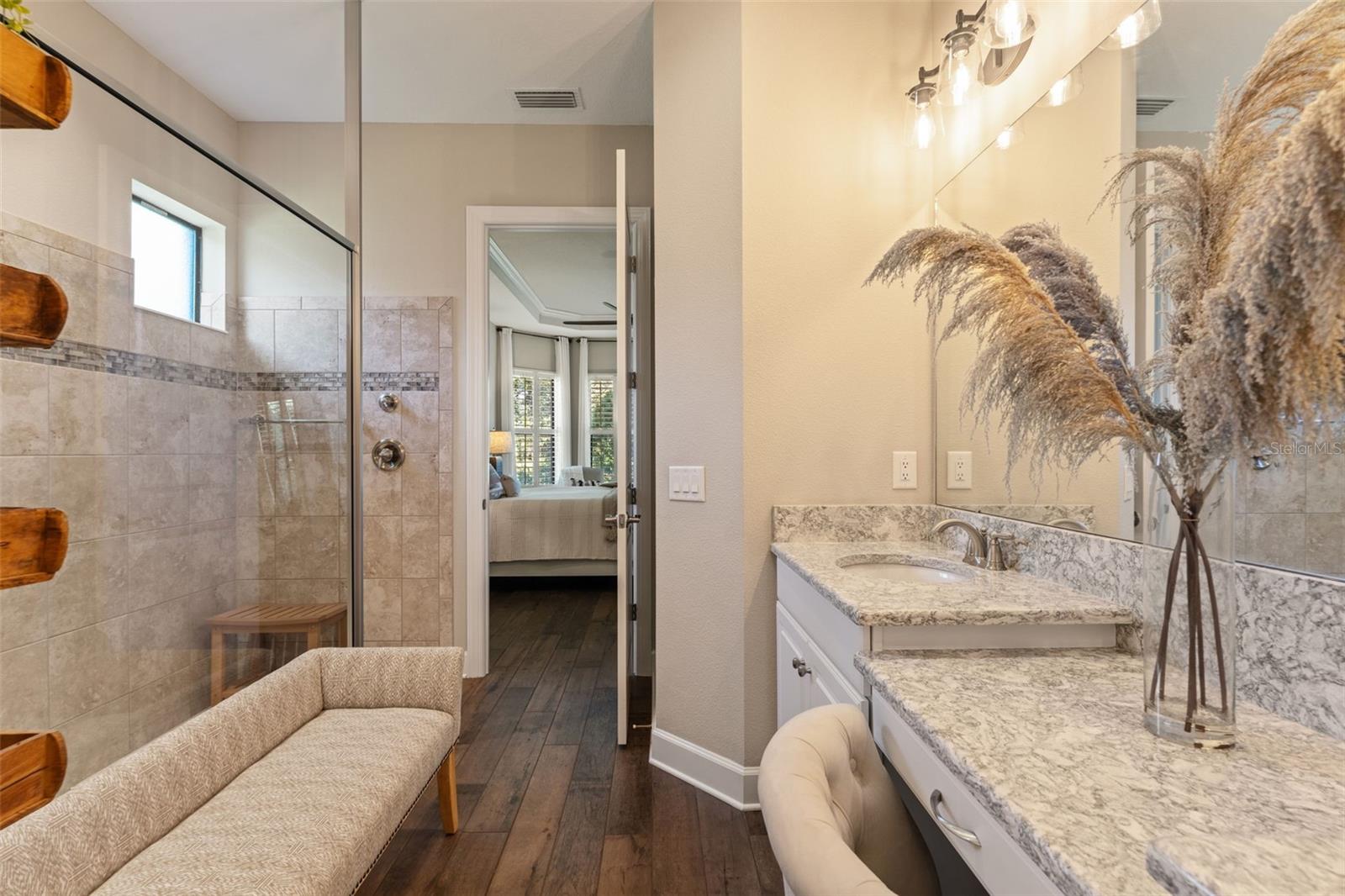 Bright and thoughtfully designed ensuite with dual vanities, granite counters, and direct access to the primary bedroom for ultimate convenience.