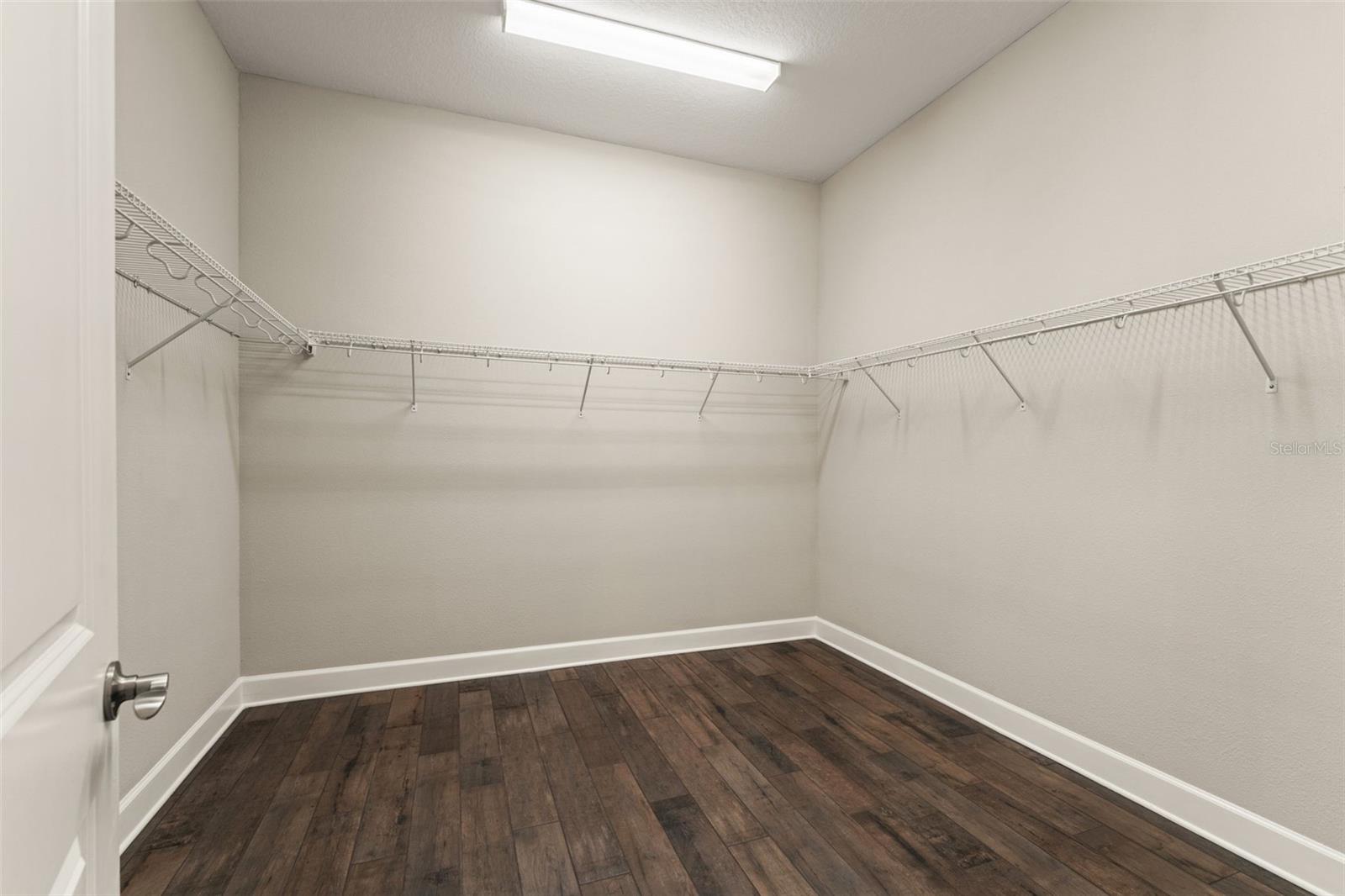 Oversized walk-in closet with custom shelving potential and ample space to organize a full wardrobe with ease.