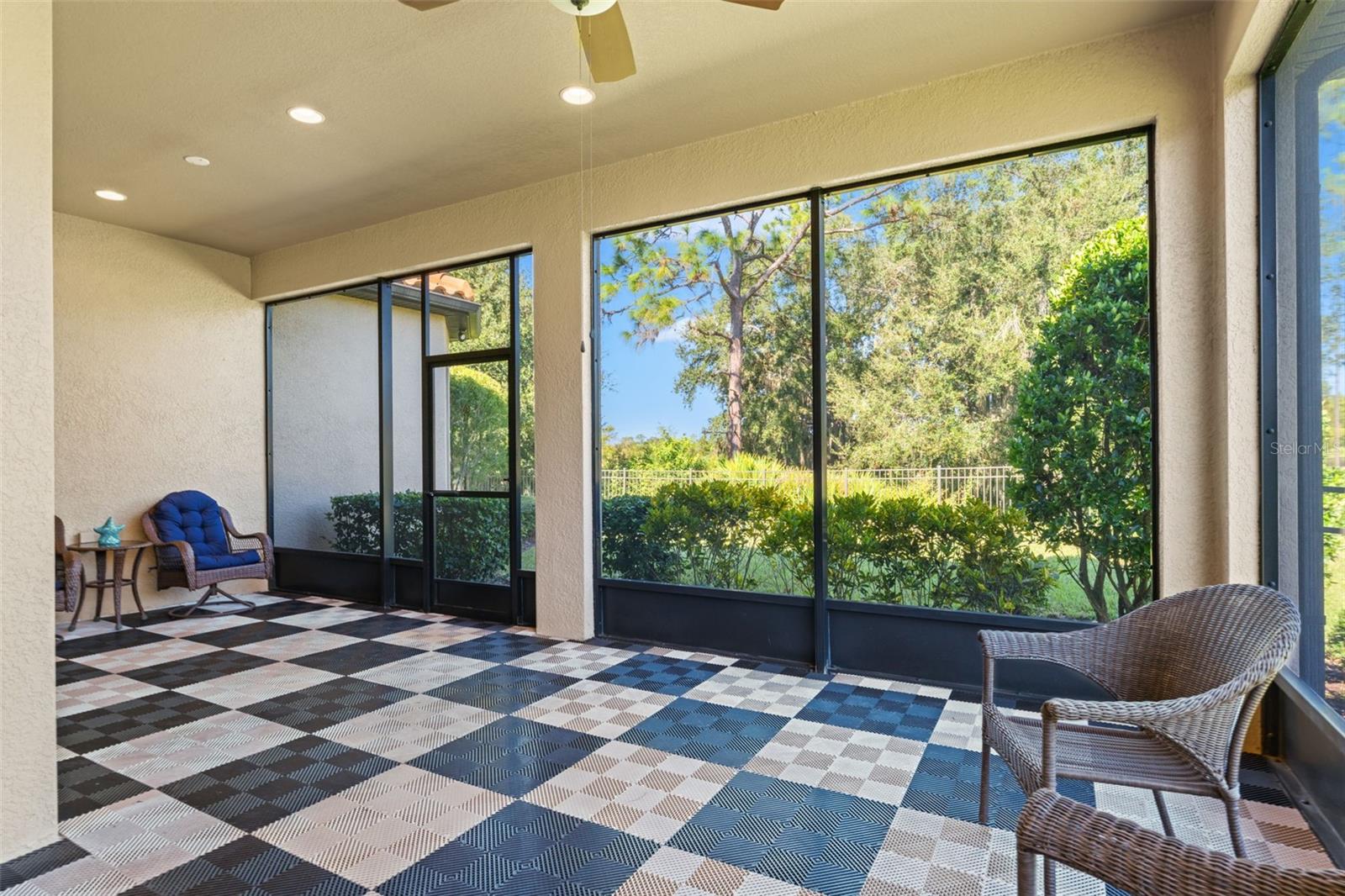 Comfortable outdoor living space with ceiling fan and privacy screening, ideal for entertaining or quiet moments surrounded by nature